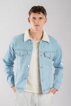 Hombre vistiendo una chaqueta de jean azul hielo con ovejero, mostrando un look vintage y relajado.