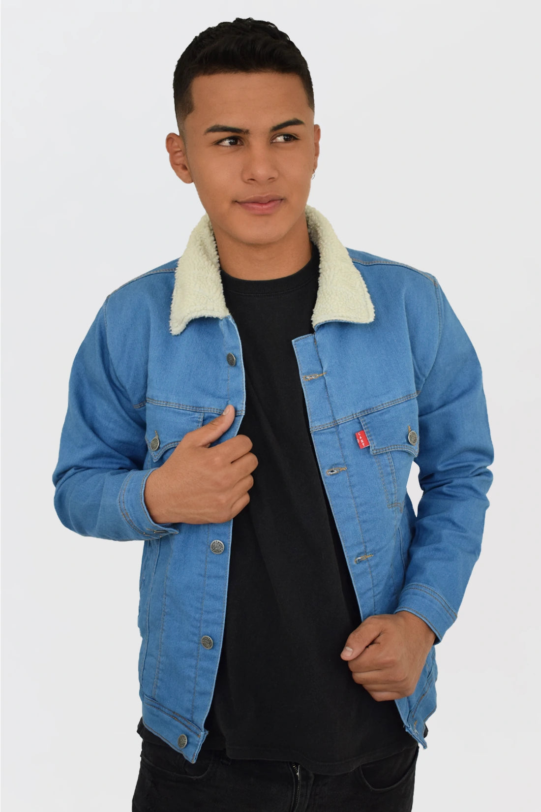 Hombre vistiendo una chaqueta de jean azul medio con ovejero, mostrando un look vintage y relajado.