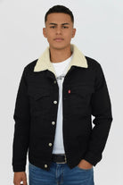 Chaqueta de jean negra para hombre, con forro y cuello de ovejero blanco en contraste, vista frontal completa.