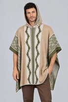 Hombre vistiendo una ruana beige modelo Durango en vista frontal, con capucha puesta, y patrones geométricos (grecas) tejidos.